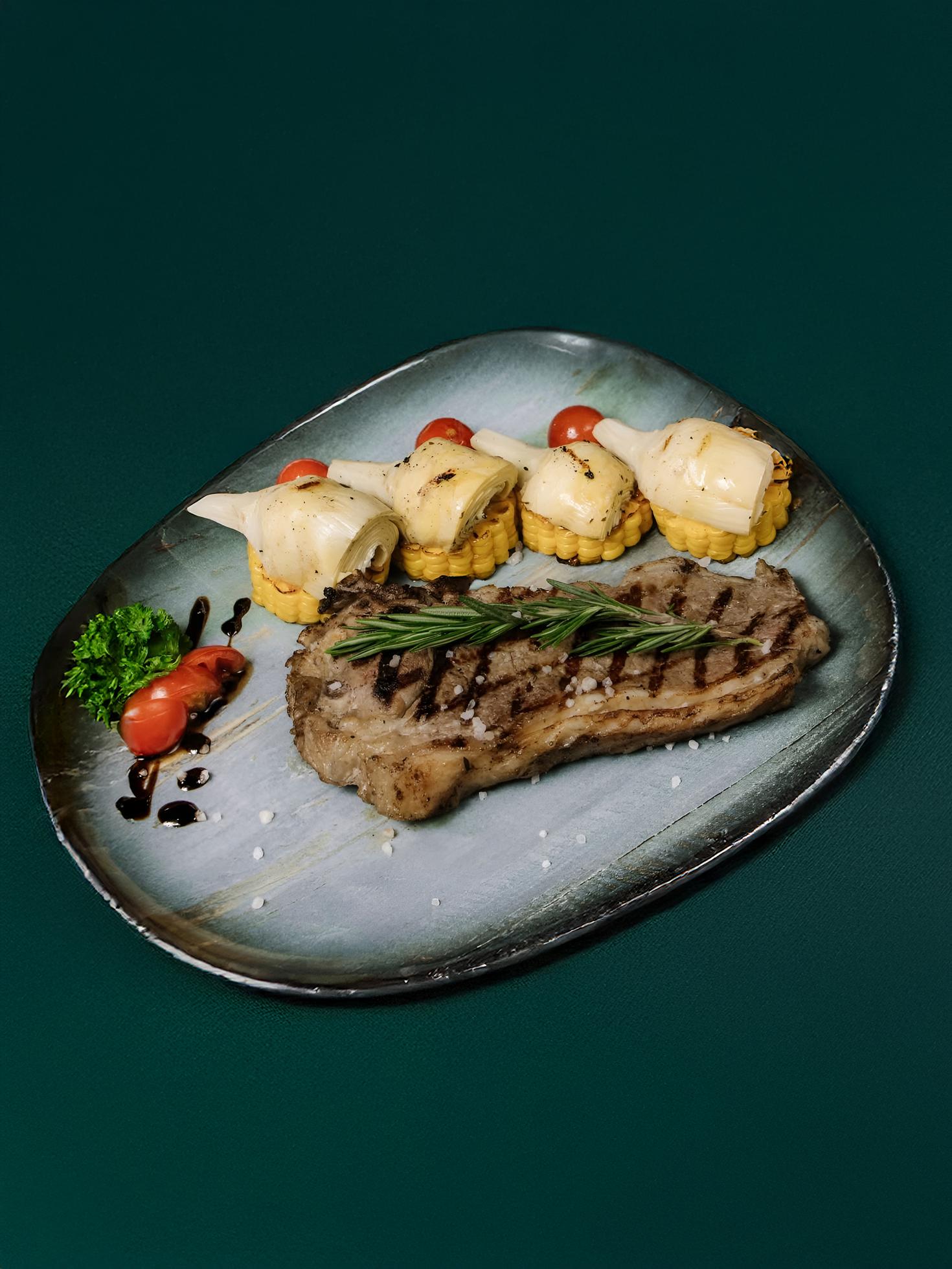 Стейк New York с артишоками и кукурузой