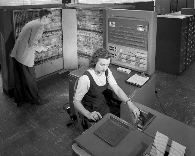 Оператор вводит данные с перфокарт в компьютер IBM 704, 1957