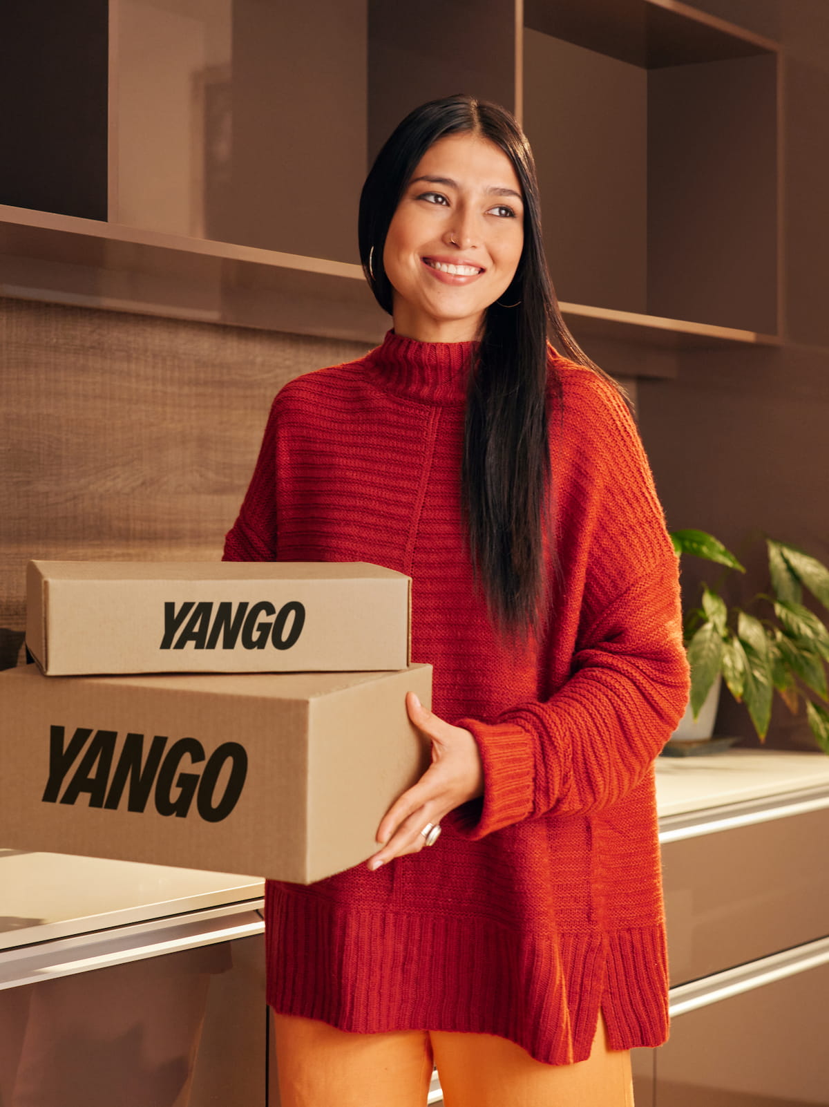 A happy woman holding Yango-labeled boxes